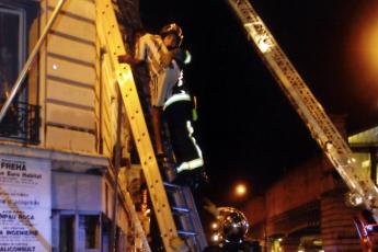 Brandweerlieden helpen een man uit het complex.