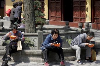 Chinezen verorberen noedels in een tempel in Sjanghai.