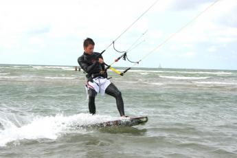 Jan Pieter Moens (19) scheert over het water, voortgetrokken door een vlieger.