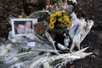 Bloemen, knuffels, flesjes bier op de plek van het ongeval.