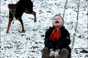 Een jongetje in Den Haag geniet van de sneeuw.