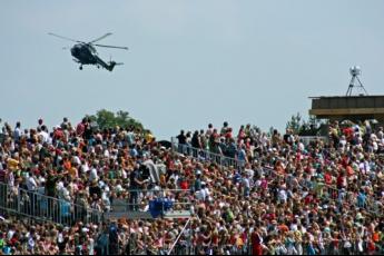 Weer enkele seconden later hangt de helikopter boven de tribune met publiek.