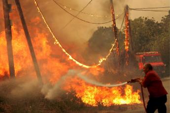 Een brandweerman probeert een bosbrand te blussen in Griekenland.