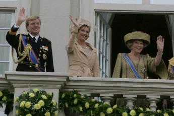 Prins Willem-Alexander, prinses Mxima en koningin Beatrix zwaaien vanaf het balkon naar de toeschouwers.