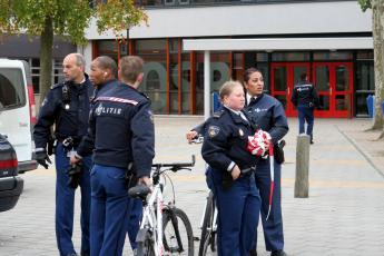 Politieagenten staan voor de ingang van de Open Scholengemeenschap Bijlmer