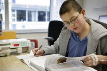 Marinus Commandeur (16) uit Bovenkarspel krijgt les in het ziekenhuis.