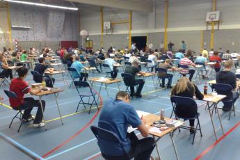 Leerlingen buigen zich in de sporthal van het Calvijn College over de examenopgaven.