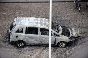 Uitgebrande auto voor het stadhuis.