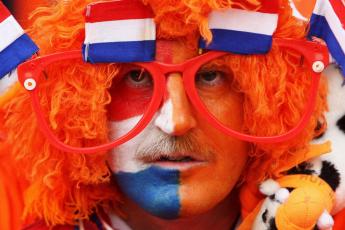 Deze meneer bekijkt de prestaties van het Nederlands elftal door een oranje bril.