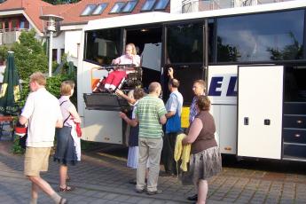 Lydia Floor uit Alblasserdam wordt met een lift uit de bus getild.