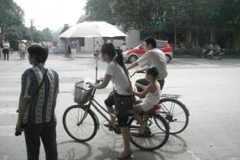 Veel Chinese vrouwen dragen een parasol tegen de zon.