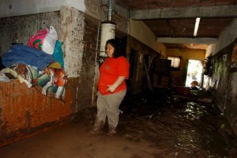 Een Mexicaanse vrouw bekijkt de situatie in haar huis nadat regenval en overstromende rivieren haar huis onder water hebben gezet. Mexico maakt zich op voor storm Dolly.