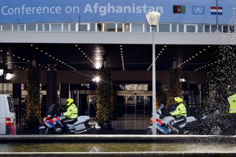 Politieagenten op motors bewaken het zwaar beveiligde pand.