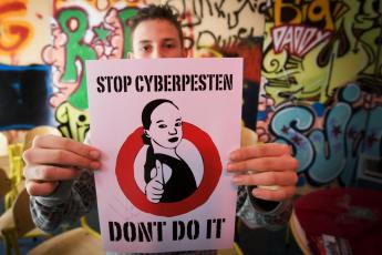 Een leerling met zijn poster tegen het Cyberpesten maandag bij school De Wissel in Amsterdam.