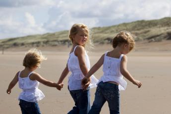 Prinsesjes Amalia (M), Alexia (R) en Ariane op het strand in Wassenaar.