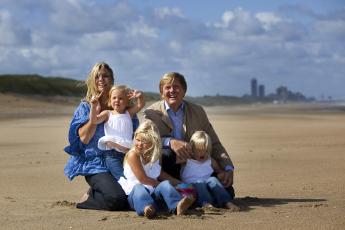 Prins Willem-Alexander en prinses Maxima poseren maandag met hun kinderen prinses op het strand.