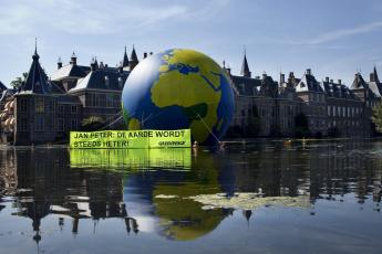 Premier Balkenende kijkt vanuit zijn torentje precies op de wereldbol.