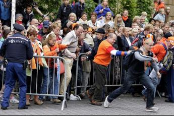 Het publiek staat rijendik achter de hekken om een glimp van de koninklijke familie op te vangen.